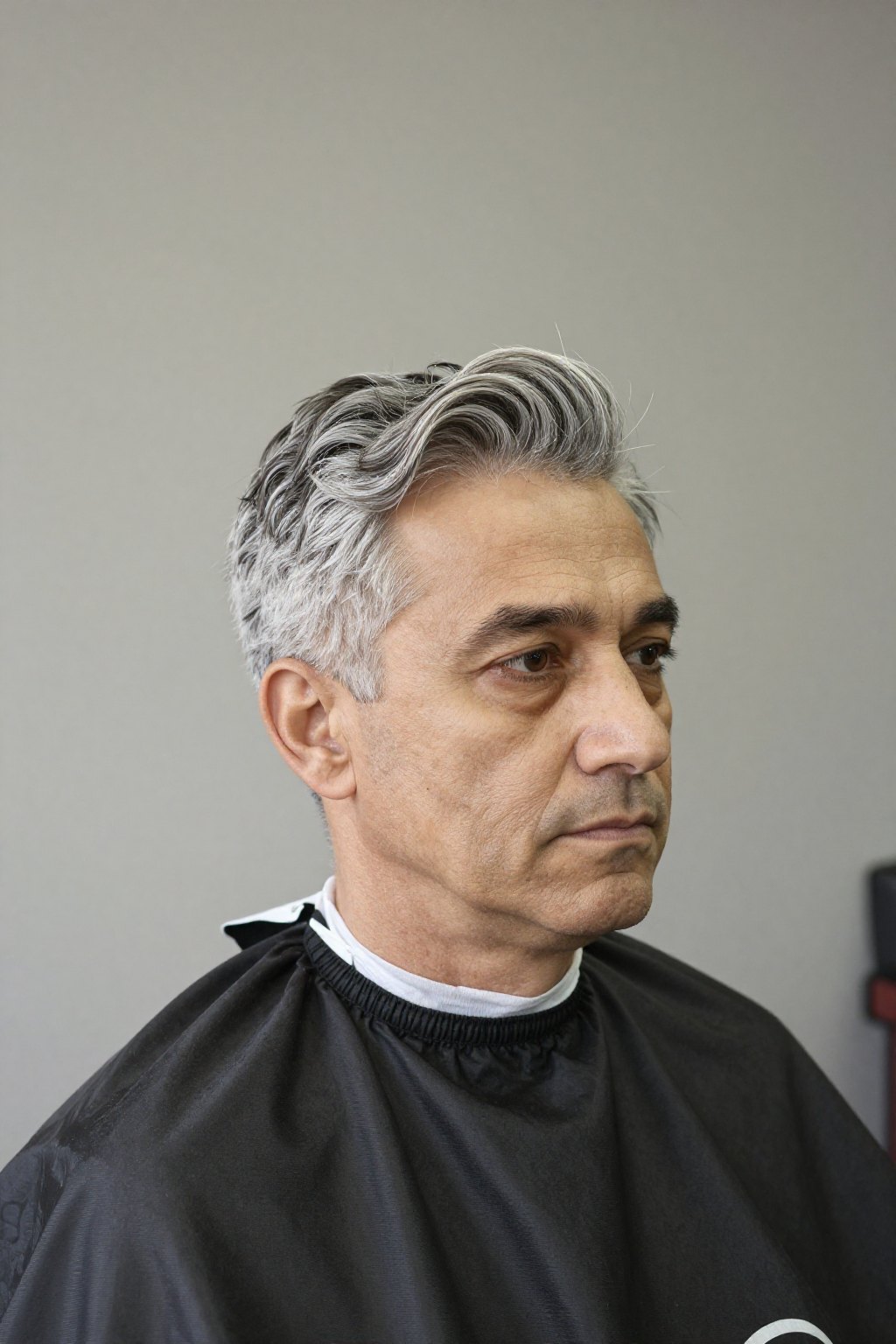 Portrait of a senior barber with grey hair and a short beard