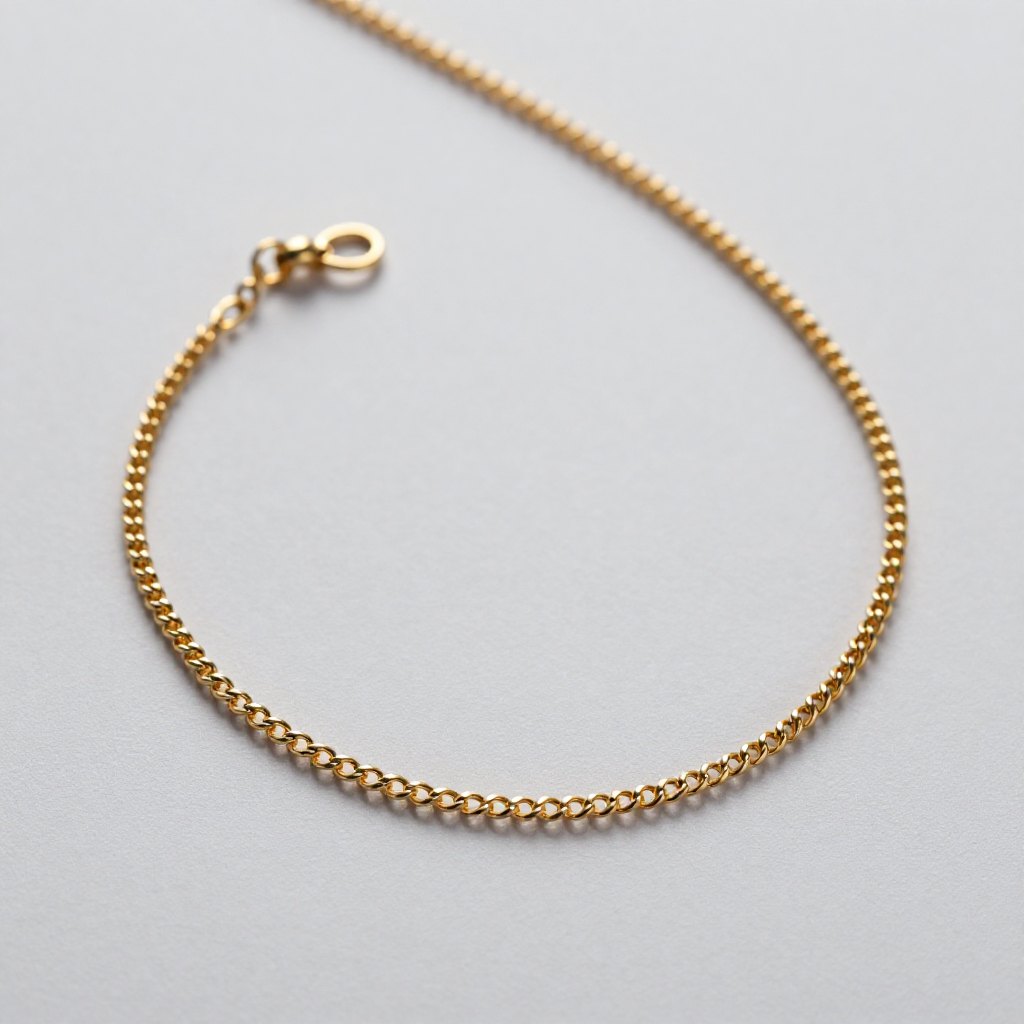 Gold chain necklace arranged on pale grey paper