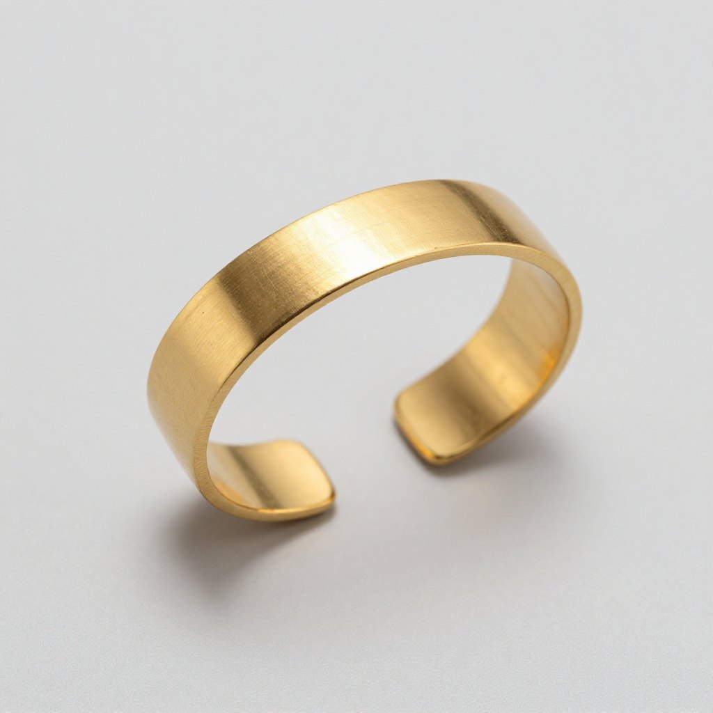 Brushed gold cuff bracelet on a pale grey surface