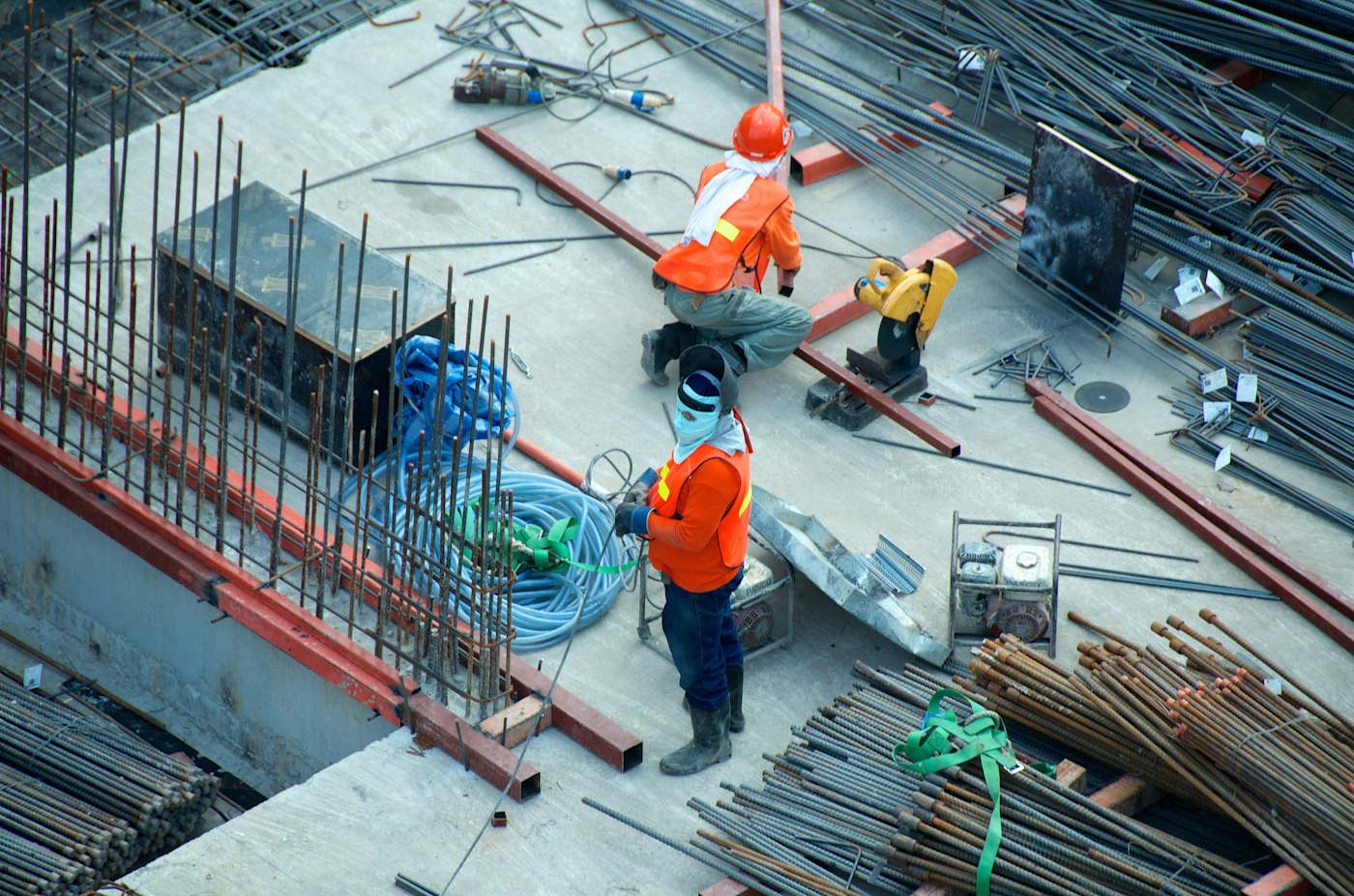 Workers in hi-vis fixing steel reinforcement on the slab of a residential build